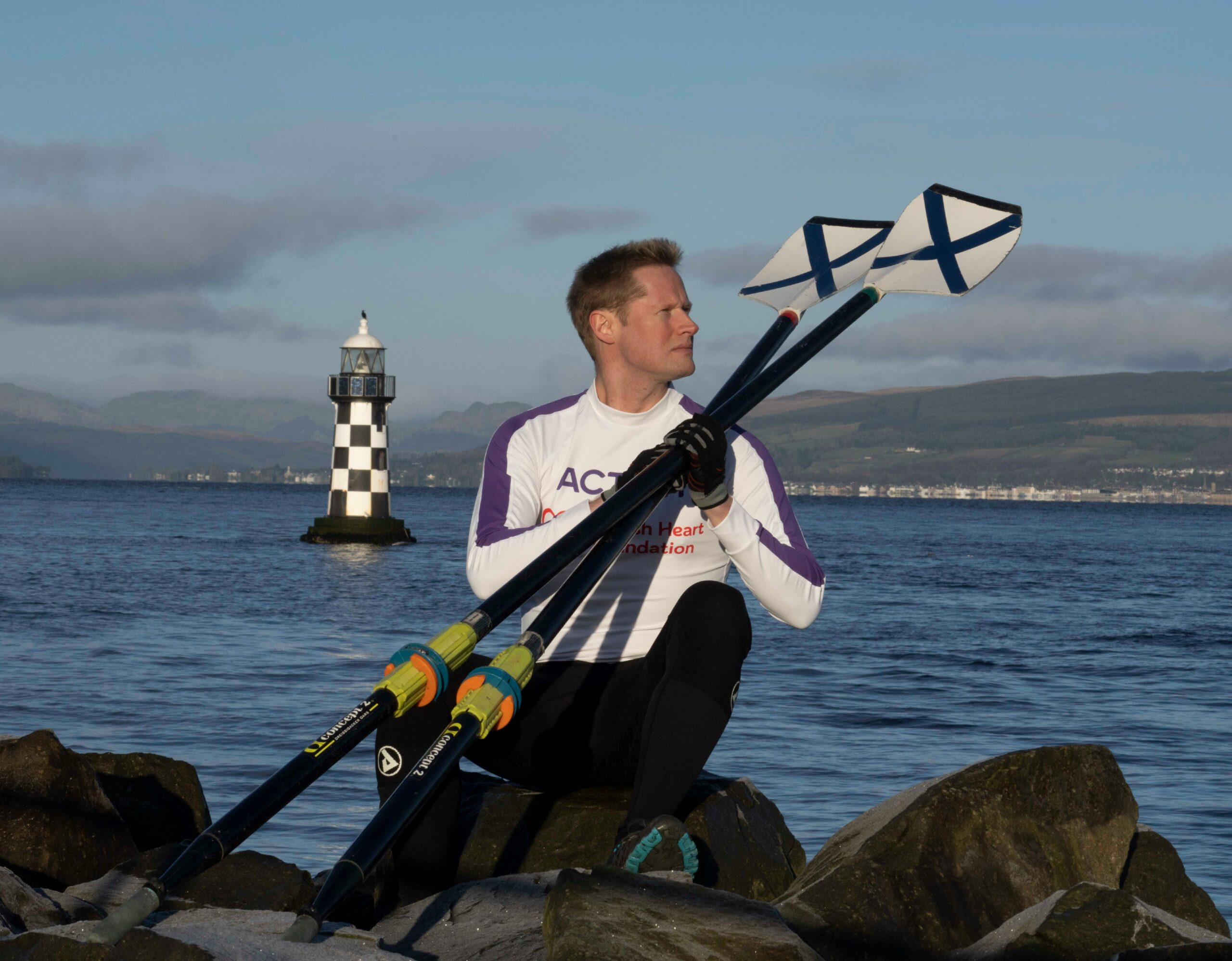 Profile picture of Jamie Douglas Hamilton overlooking the ocean and holding two oars.