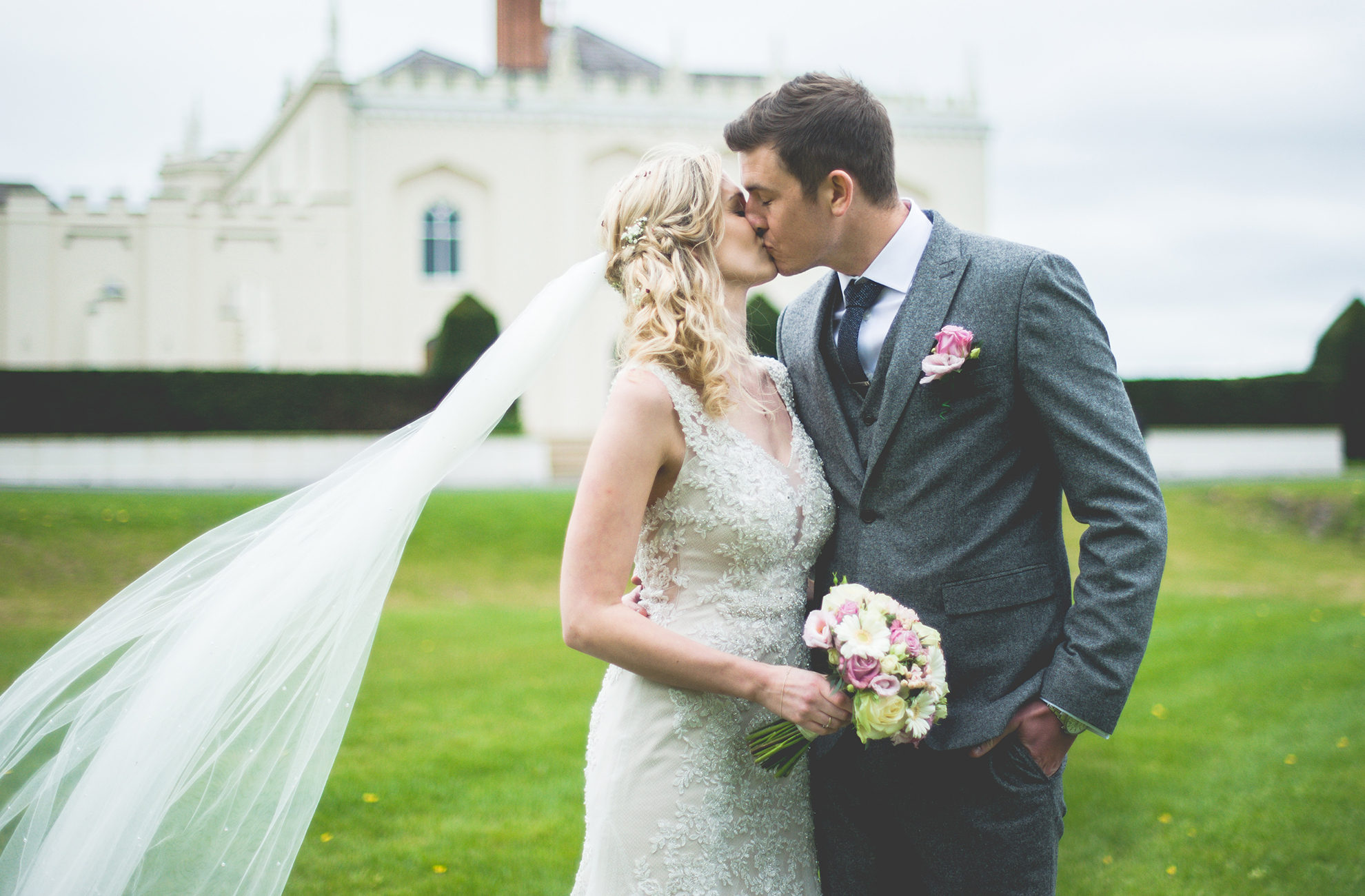 The happy couple steal a moment away from the wedding party and kiss in front of the North Wing – spring wedding