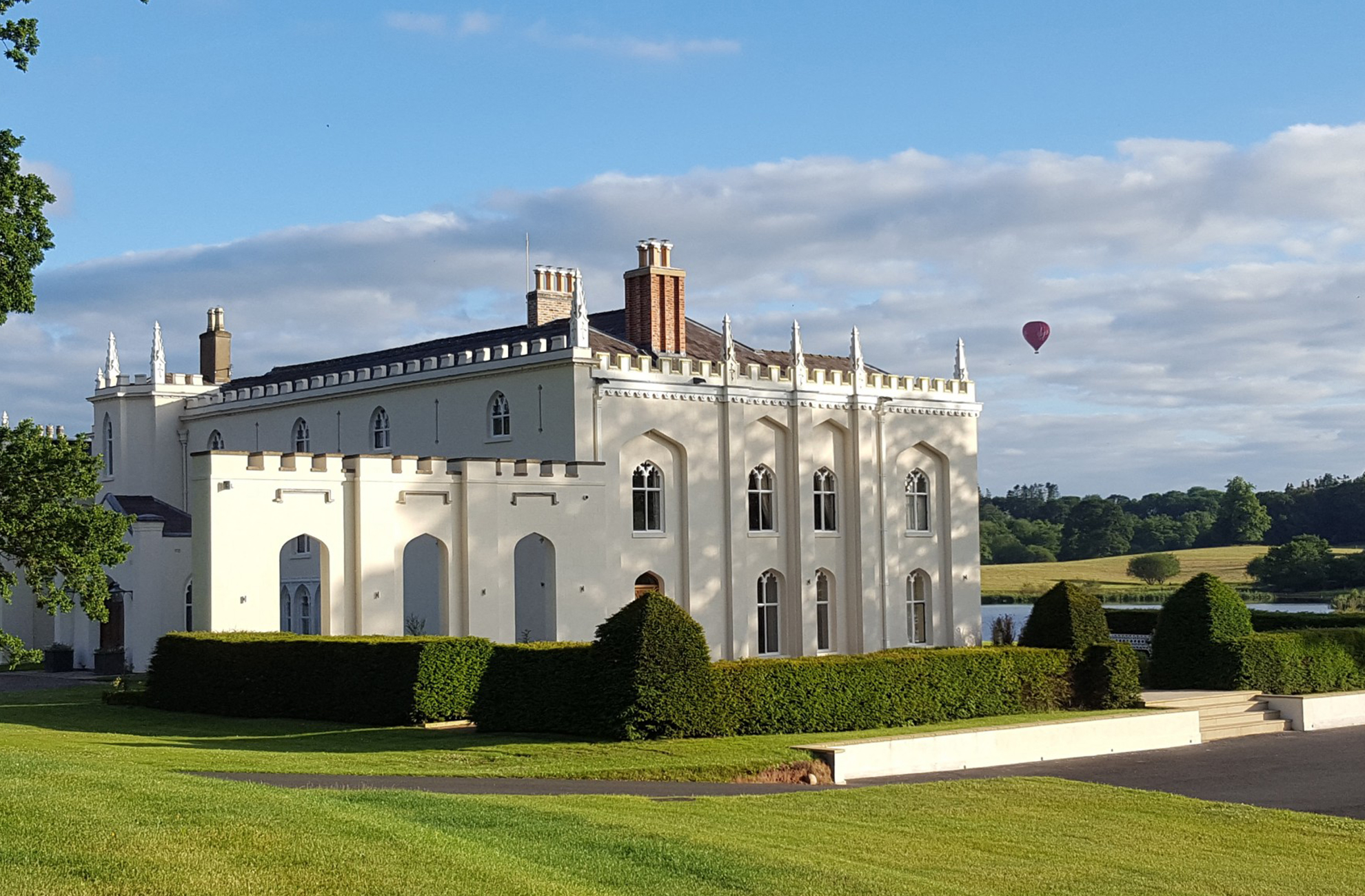 A hot air balloon elegantly flies over the abbey