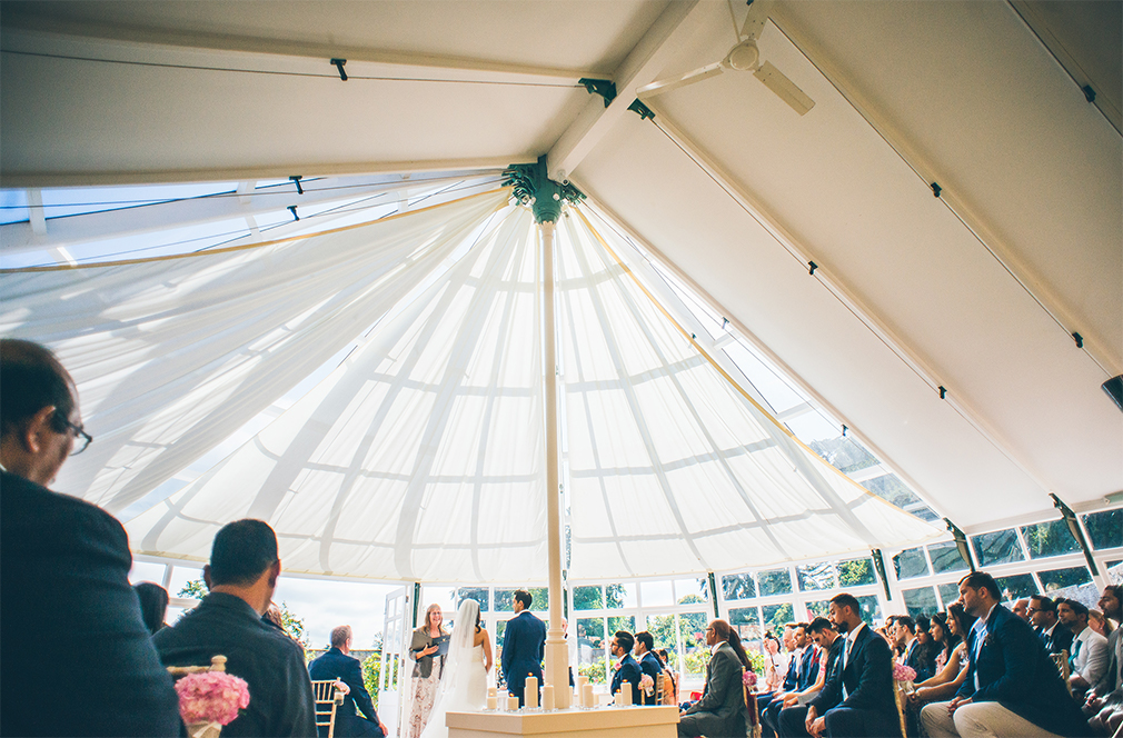 The bride and groom exchange marriage vows in the beautiful building the Glasshouse