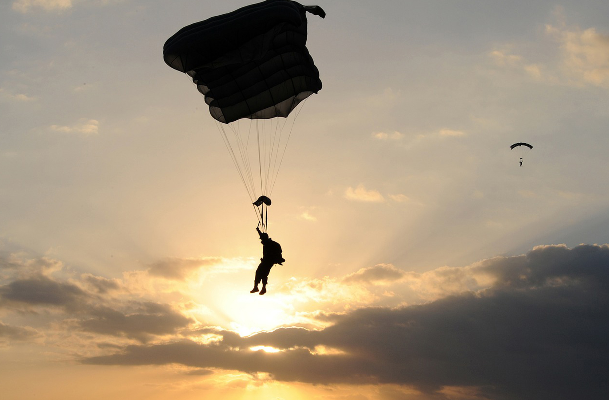 Skydivers get an adrenaline rush by skydiving at sunset