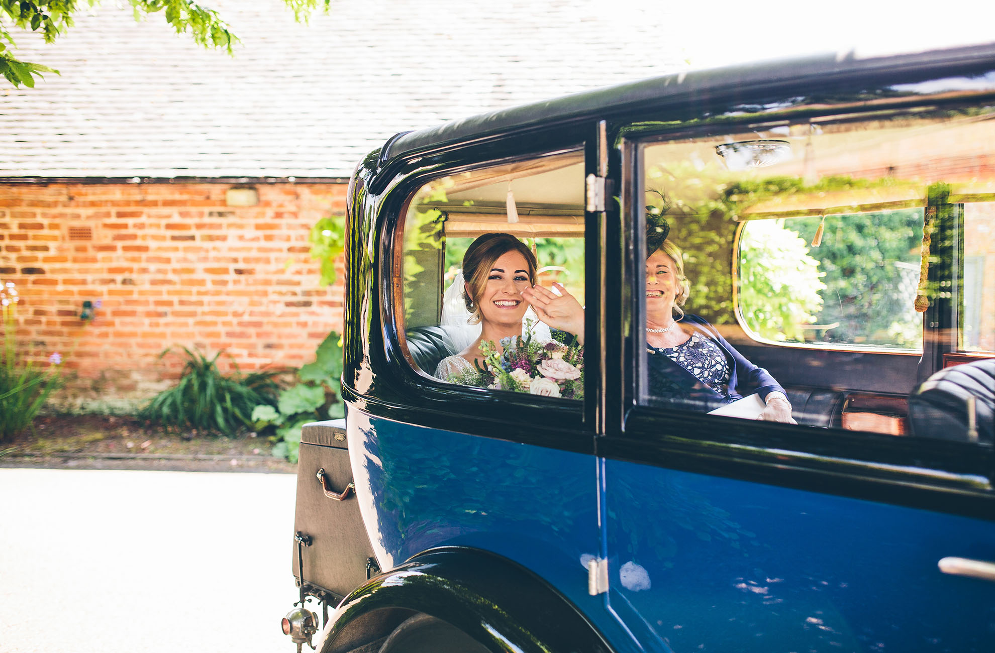 The bride arrives for her wedding ceremony at Combermere Abbey in the dedicated Crossley car