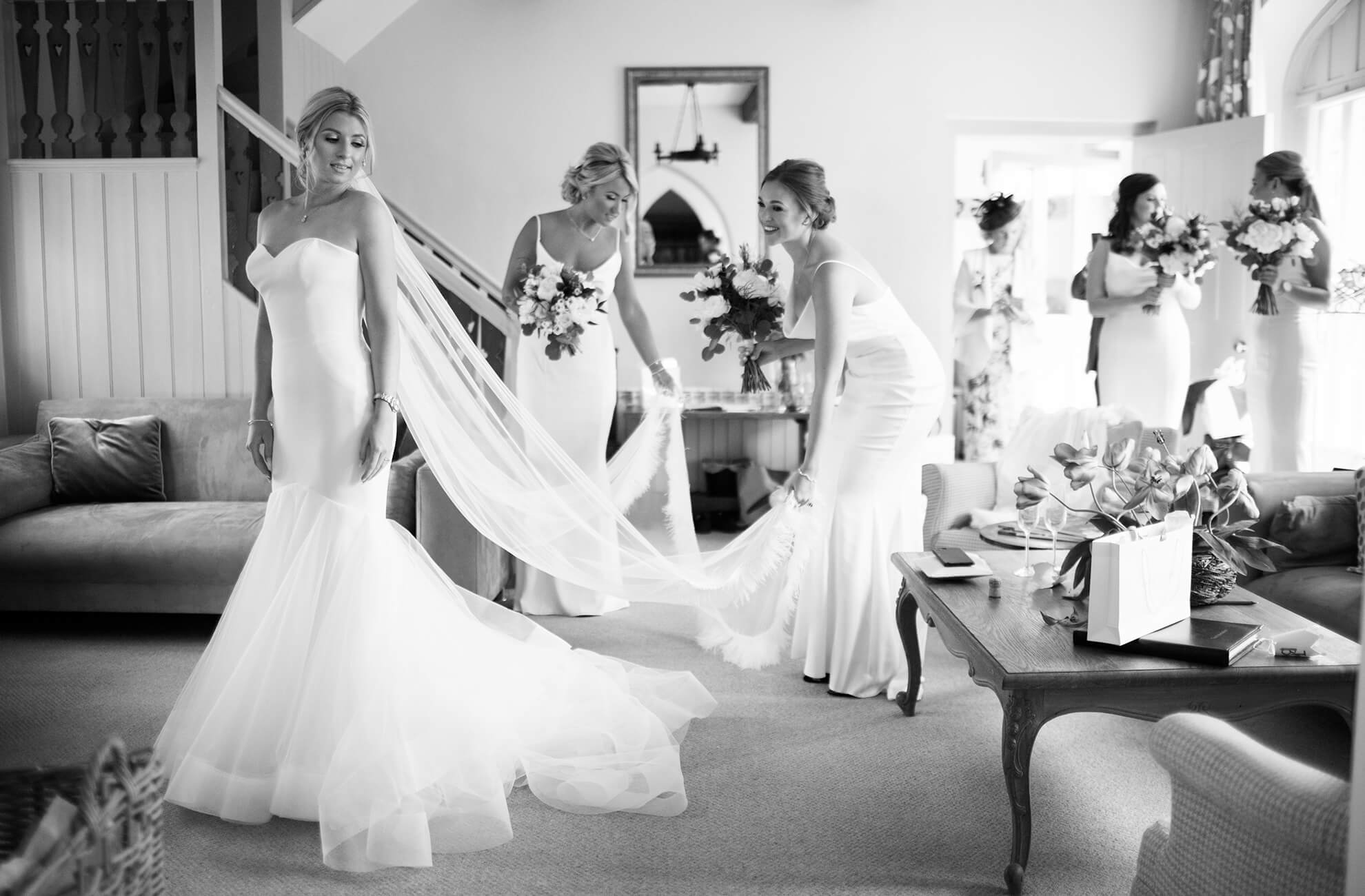 Bridesmaids help the bride with last minute preparations on the morning of her wedding day