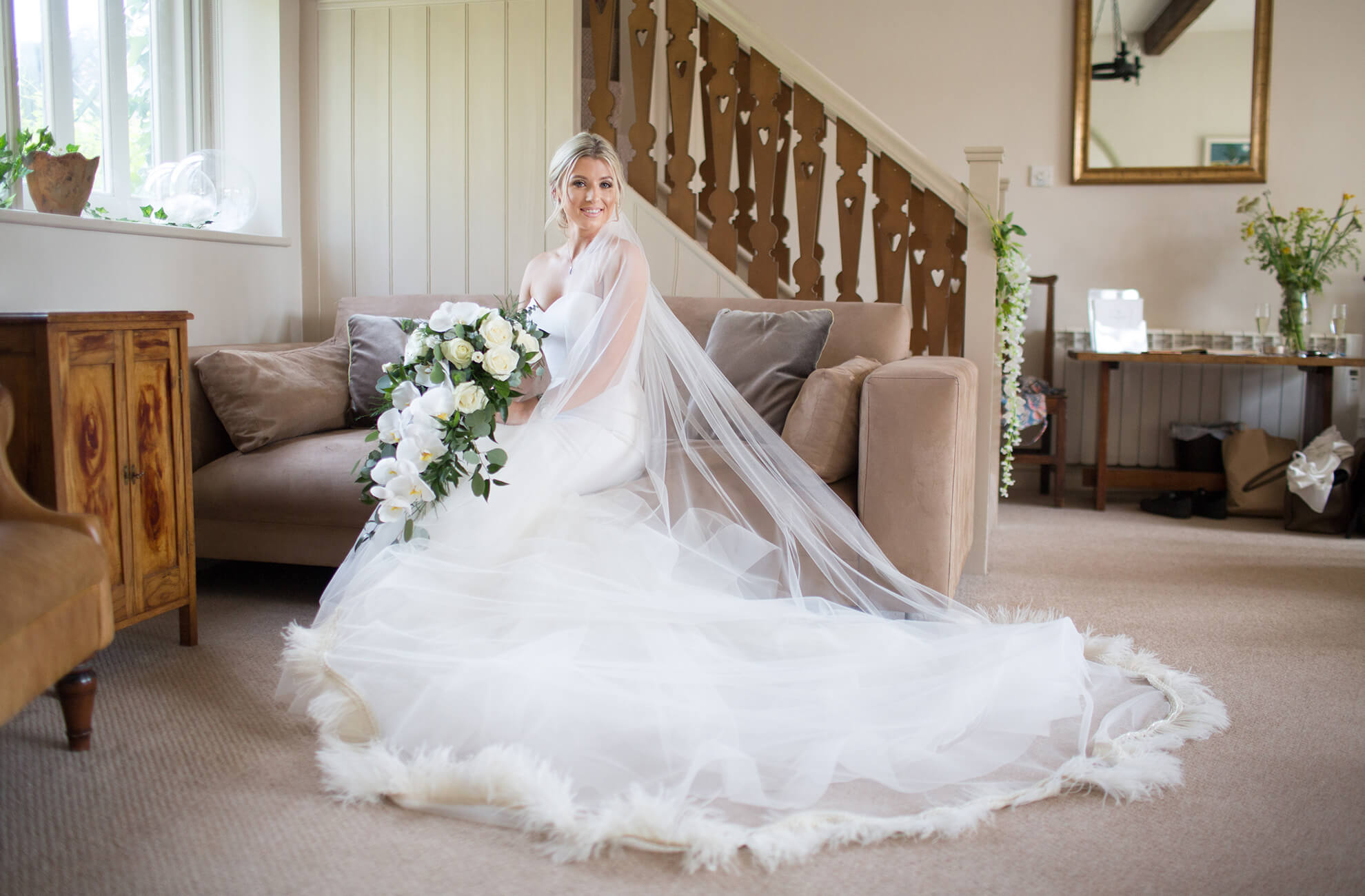 For her wedding day the bride wears a beautiful white bridal gown with a feather edged veil