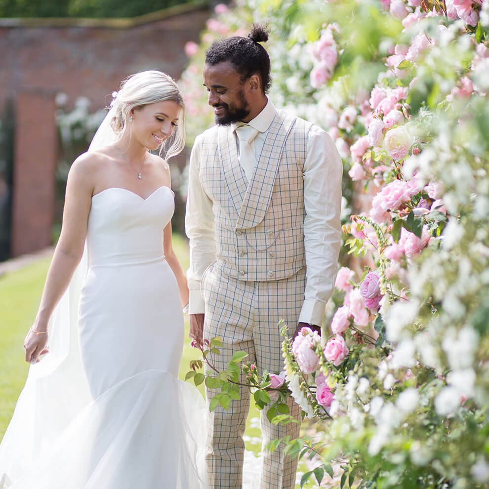 The newlyweds take time away from guests to explore the walled gardens at Combermere Abbey on their wedding day