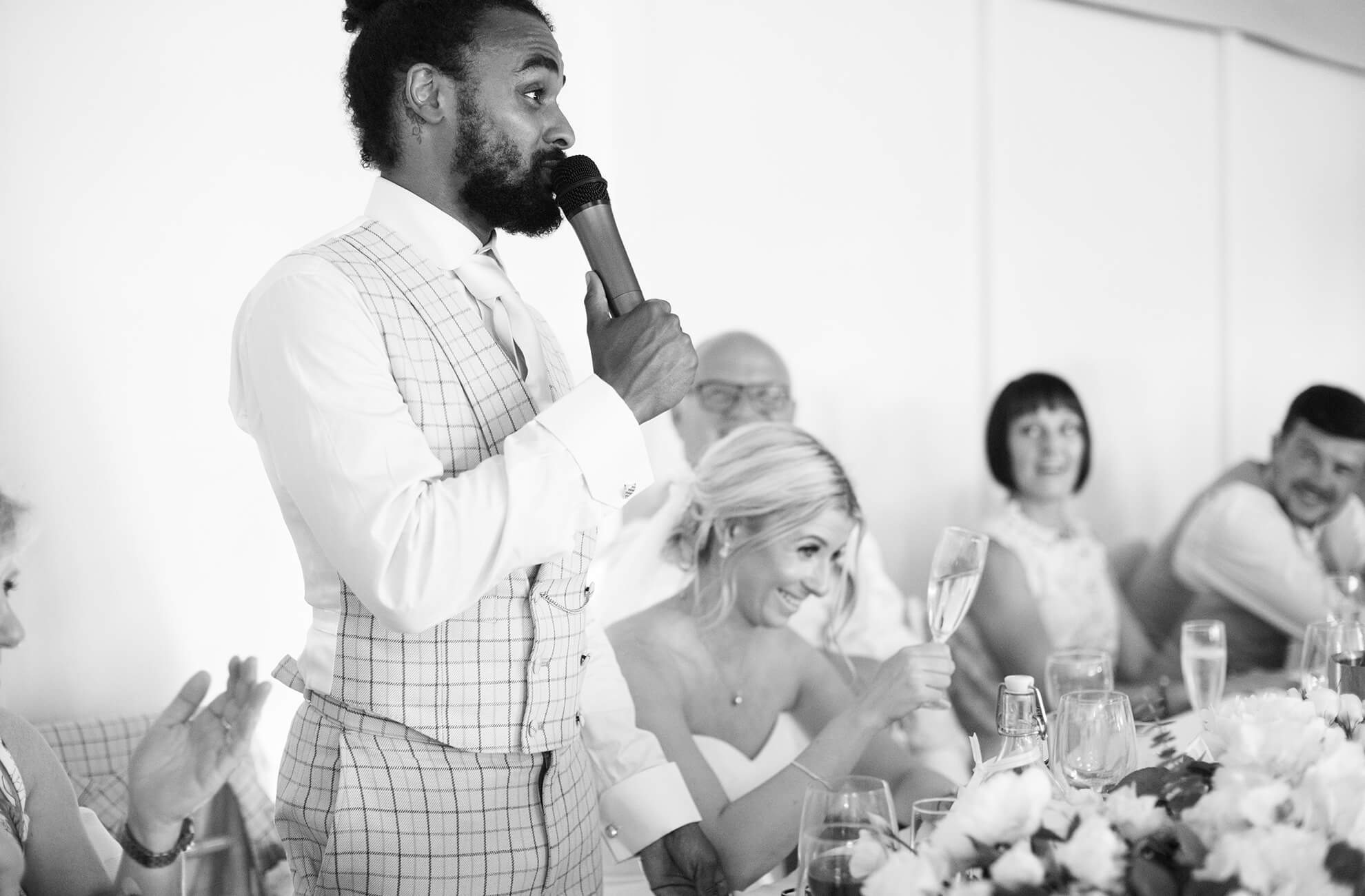 The groom makes wedding guests laugh as he proceeds with his wedding speech at Combermere Abbey
