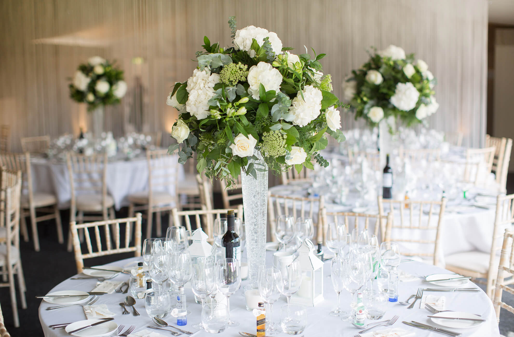 White and green floral table centerpieces adorned tables for the wedding reception