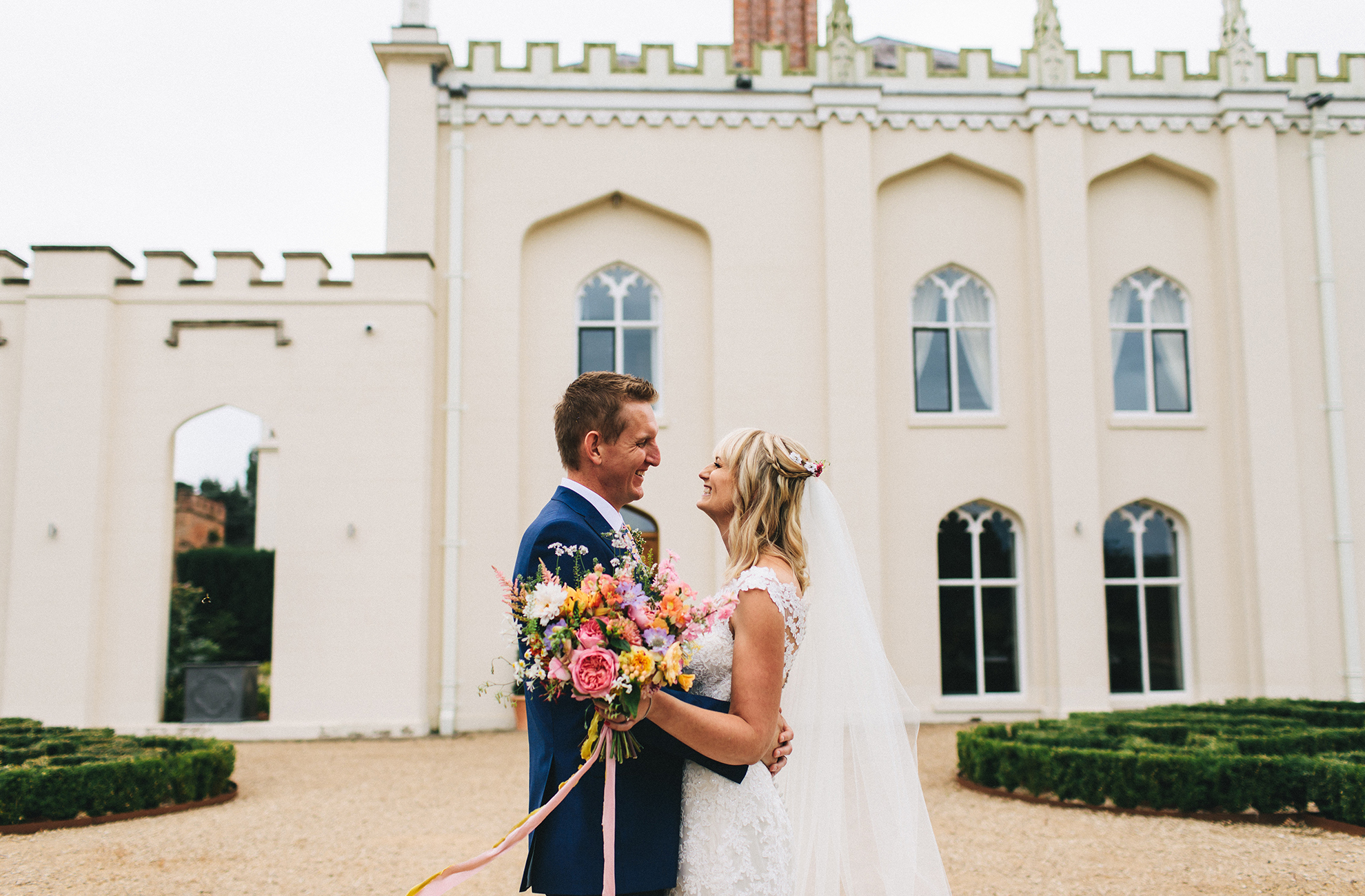 A bride and groom explore the grounds at Combermere Abbey on their wedding day