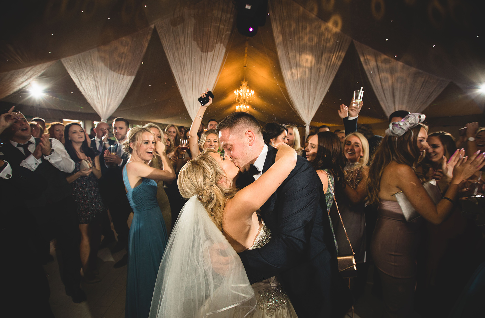 Newlyweds kiss as their guests enjoy their first dance at Combermere Abbey